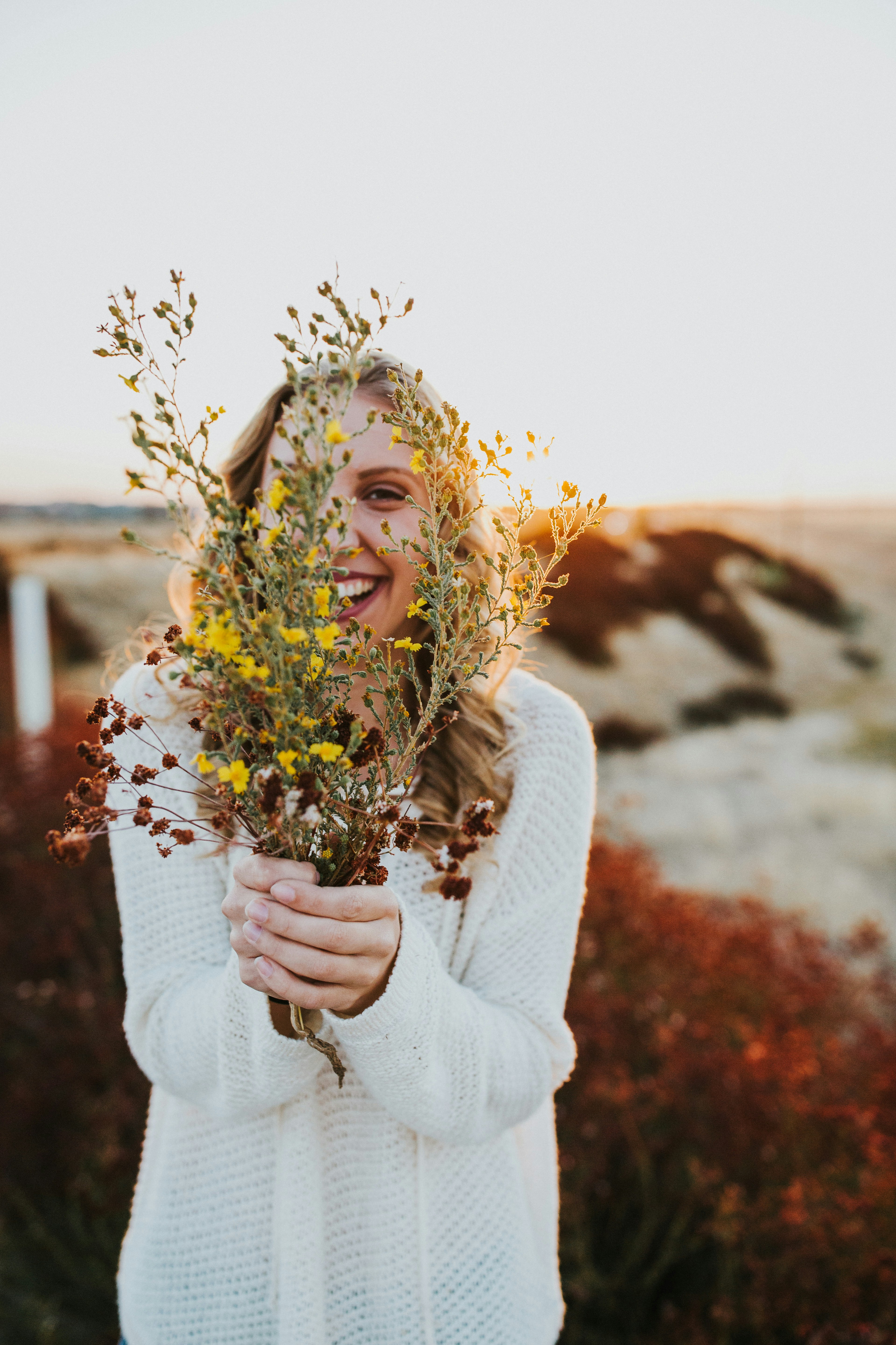 A woman filled with bliss, holding flowers.