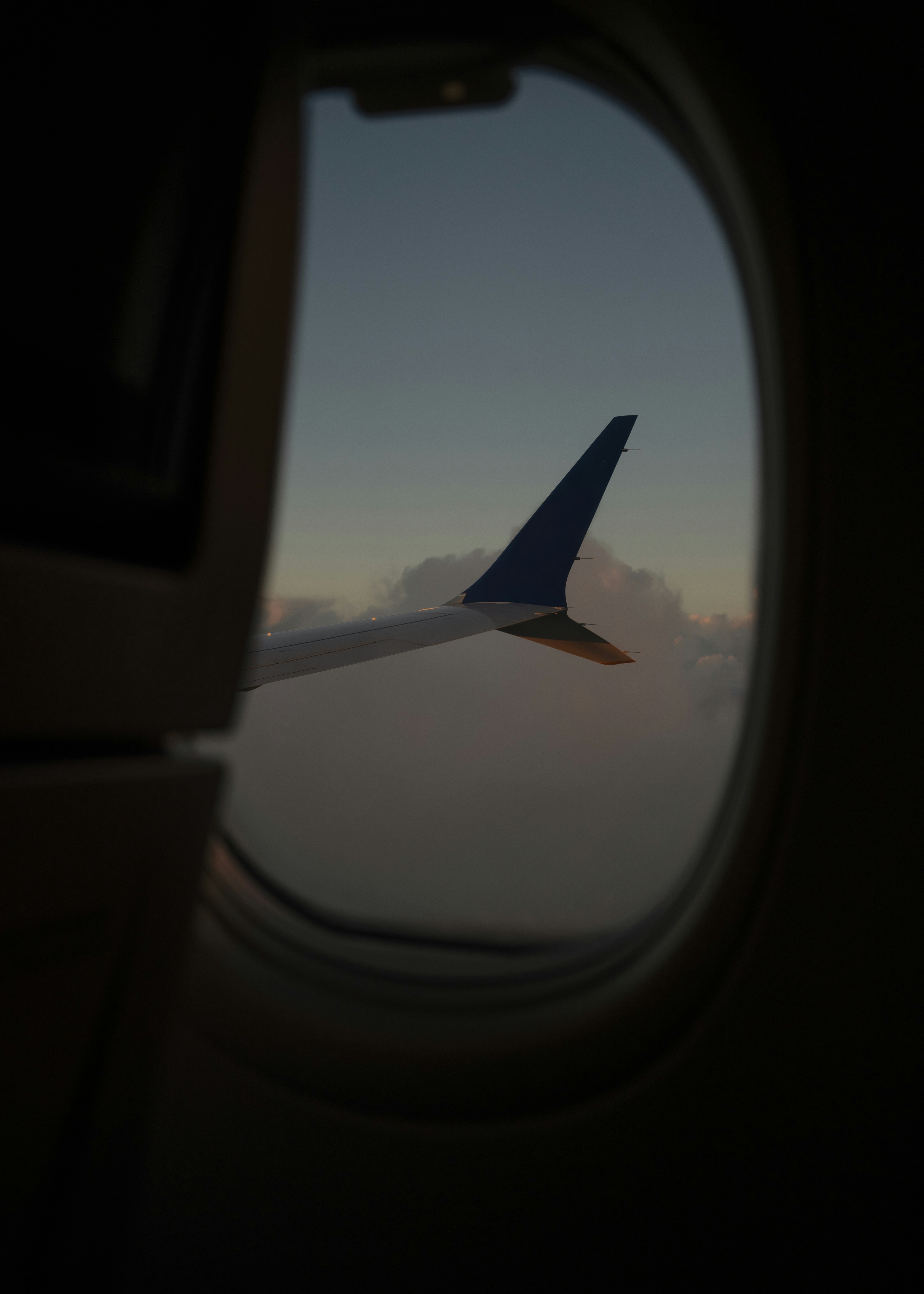 A plane carrying passengers through the barely sunlit skies.