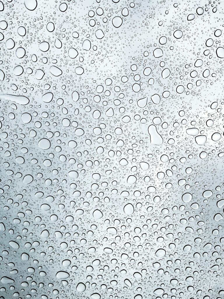 A glass window covered with rain.