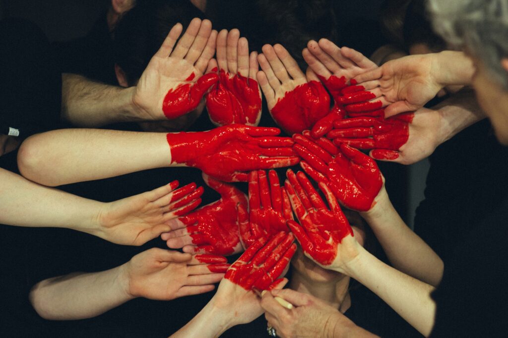 Many hands are painted to form a heart.